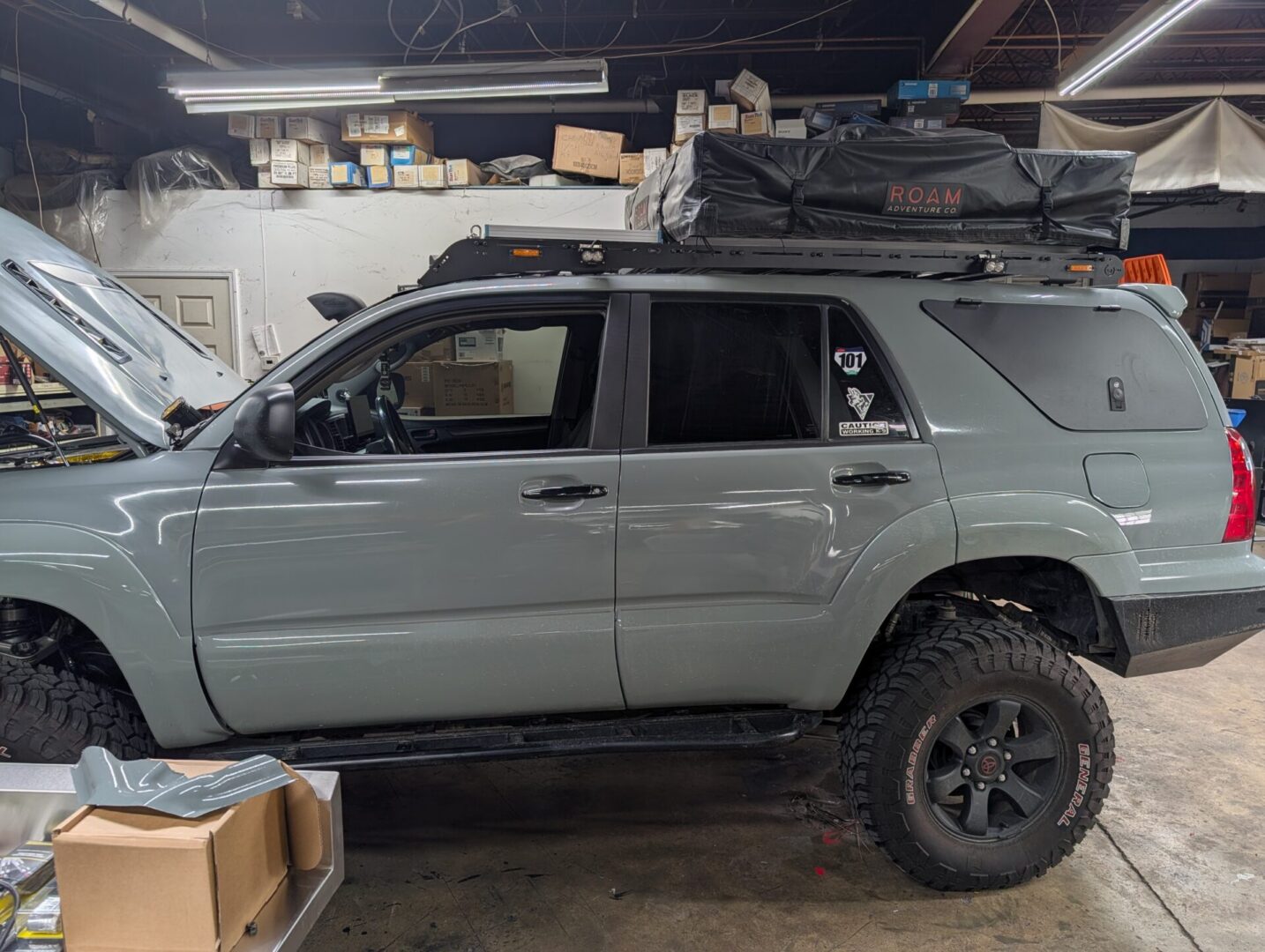 Gray SUV with roof tent in garage