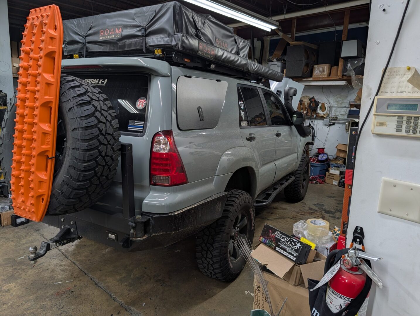 Silver SUV with rooftop tent and spare tire