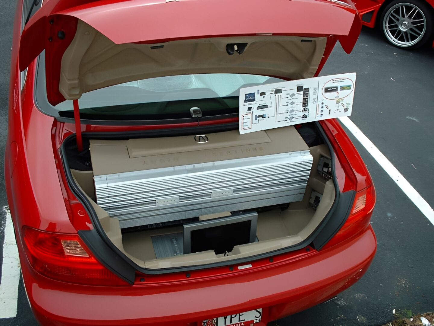 Open red car trunk with custom audio equipment